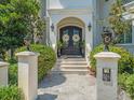 Close-up view of the ornate front door, pillars, and manicured landscaping of this grand home at 124 Estado Ne Way, St Petersburg, FL 33704
