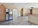 Open-concept living space featuring stainless fridge, light walls, laminate flooring, and archways at 12502 Tocci Ln, Riverview, FL 33579