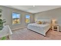 Bright bedroom with large windows, neutral walls, and a comfortable queen-size bed at 12950 Pasture Woods Pl, Lithia, FL 33547