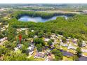 Scenic aerial view of the property nestled among lush trees, near a lake and canals for waterfront living at 1407 Jean St, Lutz, FL 33548