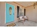 Inviting front porch with a bright blue door, cozy seating, and charming decor creates a welcoming entrance to the home at 1501 Wisconsin Ave, Palm Harbor, FL 34683