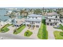 Expansive aerial view of a waterfront home showcasing its manicured lawn, boat lift, and neighborhood at 16025 Redington Dr, Redington Beach, FL 33708