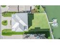 Top-down aerial view of a house with a metal roof, lush green lawn, and private boat dock on the water at 16025 Redington Dr, Redington Beach, FL 33708