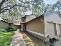 Home featuring manicured lawn, sidewalk, and a separate garage at 1693 Fry Ct, Dunedin, FL 34698