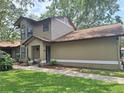 Exterior view of house featuring manicured lawn, sidewalk, and a pleasing color scheme at 1693 Fry Ct, Dunedin, FL 34698
