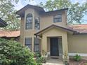 Inviting home exterior featuring neutral stucco, decorative plants, and an eye-catching arched window at 1693 Fry Ct, Dunedin, FL 34698