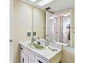Comfortable bathroom with a tiled vanity, large mirror, lighting fixtures, and doorway view at 17920 Gulf Blvd # 1302, Redington Shores, FL 33708