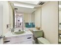 Cozy bathroom with a vanity, mirror, tiled countertops, fixtures, and a view into an adjacent hallway at 17920 Gulf Blvd # 1302, Redington Shores, FL 33708