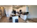 Bright kitchen with white cabinetry, modern appliances, and a spacious center island with bar stools at 1853 Hovenweep Rd, Wesley Chapel, FL 33543