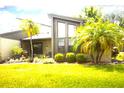 Contemporary home featuring a well-manicured lawn and lush landscaping, including vibrant palm trees enhancing curb appeal at 2101 Sunset Point Rd # 1806, Clearwater, FL 33765