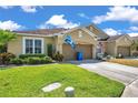 Exterior view of home with green lawn, landscaping, driveway, and attached garages at 30327 Lettingwell Cir, Wesley Chapel, FL 33543