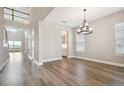 Open dining room with wood floors, modern chandelier, and ample natural light at 34084 Torrent Ln, Wesley Chapel, FL 33543