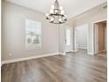 Bright dining area with wood floors and a modern chandelier, ideal for entertaining at 34084 Torrent Ln, Wesley Chapel, FL 33543