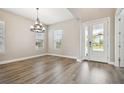Inviting dining room with stylish lighting, wood floors, and a view of the front yard at 34084 Torrent Ln, Wesley Chapel, FL 33543