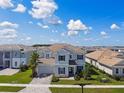 Two-story home featuring a well-manicured front yard, a tile roof, and a paver driveway in a neighborhood at 34084 Torrent Ln, Wesley Chapel, FL 33543