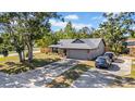 Angle view of brick home with a long driveway, cars parked outside and lawn at 4085 37Th N Ave, St Petersburg, FL 33713