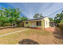 Quaint yellow house showcasing a screened porch and tidy landscaping at 4517 2Nd S Ave, St Petersburg, FL 33711