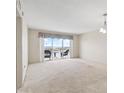 A living room with carpet flooring, a sliding glass door to a balcony with a view of the water at 4900 Brittany S Dr # 1810, St Petersburg, FL 33715