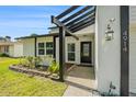 Welcoming front entrance with landscaped garden beds and attractive black-frame pergola at 4914 Country Hills Dr, Tampa, FL 33624