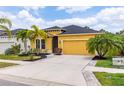 Charming yellow home with a two-car garage, beautiful landscaping and a well-maintained lawn at 5048 Inshore Landing Dr, Apollo Beach, FL 33572