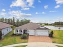 Stunning aerial view of a home near a tranquil lake, showcasing the manicured lawn and three-car garage at 5670 Shorebird Br, Land O Lakes, FL 34638