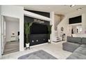 Open-concept living room featuring sleek white tile, a stylish black accent wall, and modern decor at 6233 Olivedale Dr, Riverview, FL 33578