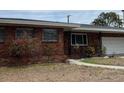 Close-up of a charming single-story brick home with an attached garage and walkway at 627 E Davis Blvd, Tampa, FL 33606
