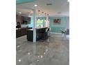 A modern, eat-in kitchen featuring an island with bar stool seating, gray cabinets, and stainless appliances at 627 E Davis Blvd, Tampa, FL 33606