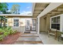 Inviting front entrance with double doors, a welcome mat, and a comfortable chair on the covered porch at 6415 13Th N Ave, St Petersburg, FL 33710