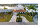 Charming waterfront home boasts lush landscaping and a circular driveway, providing stunning curb appeal at 6442 Lake Sunrise Dr, Apollo Beach, FL 33572