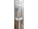 Elegant pedestal sink bathroom featuring a modern mirror and fixtures, complemented by neutral wall tones and clean lines at 6842 Dartmouth Hill St, Riverview, FL 33578