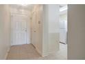 Inviting entryway with neutral tile flooring, leading to a bright kitchen with white appliances and ample storage space at 6842 Dartmouth Hill St, Riverview, FL 33578
