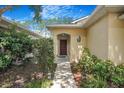 Charming home entrance with a well-kept garden and a lovely wooden front door at 7031 Kendall Heath Way, Land O Lakes, FL 34637