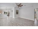 Open concept living room with wood-look floors and abundant natural light at 7031 Kendall Heath Way, Land O Lakes, FL 34637