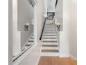 Bright stairway with light wood floors, white risers, and an elegant decorative mirror at 736 Coral Reef Dr, Tampa, FL 33602