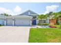 Beautiful home featuring a well-maintained lawn, tropical landscaping and a three-car garage at 7657 Nottinghill Sky Dr, Apollo Beach, FL 33572