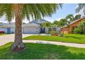 Charming home featuring well-manicured lawn, lush tropical landscaping and a three car garage at 7657 Nottinghill Sky Dr, Apollo Beach, FL 33572