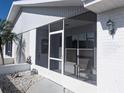 Enclosed front porch showcasing comfortable seating and a view of the landscaped yard at 810 Bluewater Dr, Sun City Center, FL 33573
