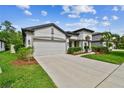 Attractive home with landscaped front yard, a spacious driveway, and a two-car garage at 8320 Bluevine Sky Dr, Land O Lakes, FL 34637