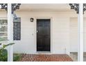 Inviting front entrance with a classic black door, tiled entryway, and decorative accents at 8696 118Th St, Seminole, FL 33772