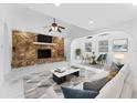 Bright living room with stone fireplace, modern decor, and a seamless open floor plan at 11709 N Armenia Ave, Tampa, FL 33612