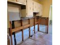 Tiled kitchen area ready for renovation, featuring upper cabinets and exposed plumbing at 1234 11Th Se Cir, Largo, FL 33771