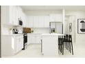 Bright kitchen featuring white cabinets, stainless steel appliances, and an island with bar stools at 12694 Lily Quartz Loop, Parrish, FL 34219
