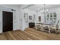 Bright home office featuring a large window, modern lighting, and laminate wood flooring at 15704 Mifflin Ct, Tampa, FL 33647