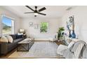Bright living room with neutral walls, wood floors, modern furniture, and plenty of natural light from two windows at 1607 34Th E Ave, Bradenton, FL 34208