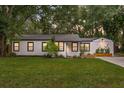 Charming single story home with a well-manicured lawn and tidy landscaping at 1715 N Alexander Rd, Tampa, FL 33603