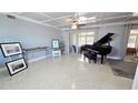 Spacious living room boasts a beautiful terrazzo floor, coffered ceilings, and grand piano at 1755 Sunset Point Rd, Clearwater, FL 33755