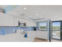 Bright, updated kitchen with white cabinets, stainless steel appliances, and modern backsplash at 18650 Gulf Blvd # 203, Indian Shores, FL 33785