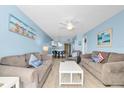 Open-concept living room with dining area featuring modern furnishings, beach-themed decor, and plenty of seating at 18650 Gulf Blvd # 203, Indian Shores, FL 33785
