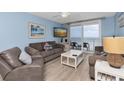 Cozy living room with blue walls, comfortable seating, and a sliding glass door to a balcony overlooking the beach at 18650 Gulf Blvd # 203, Indian Shores, FL 33785